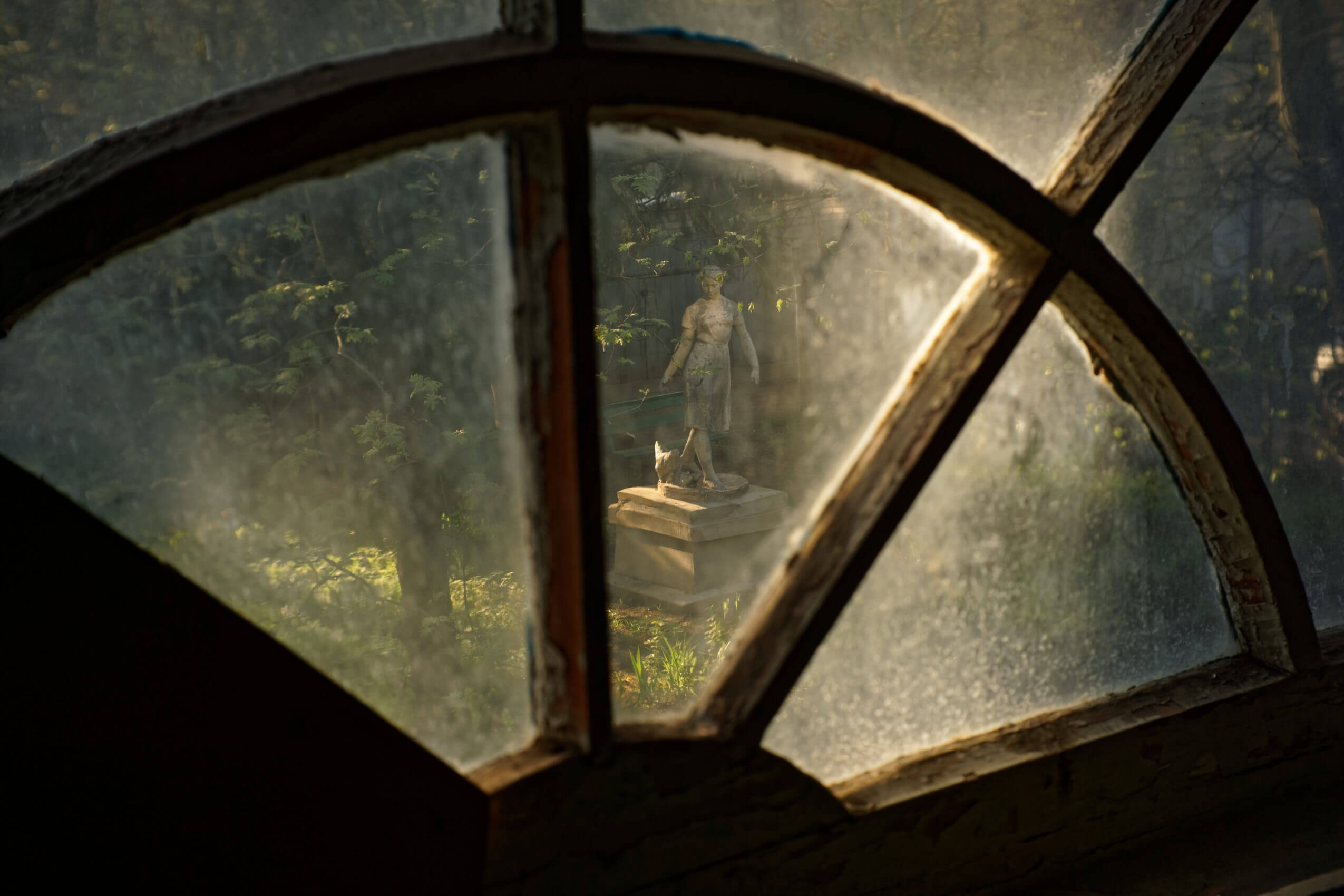 Словно кадр из фильма - скульптура девушки через винтажное окно подъезда в Заволжском районе Твери. 